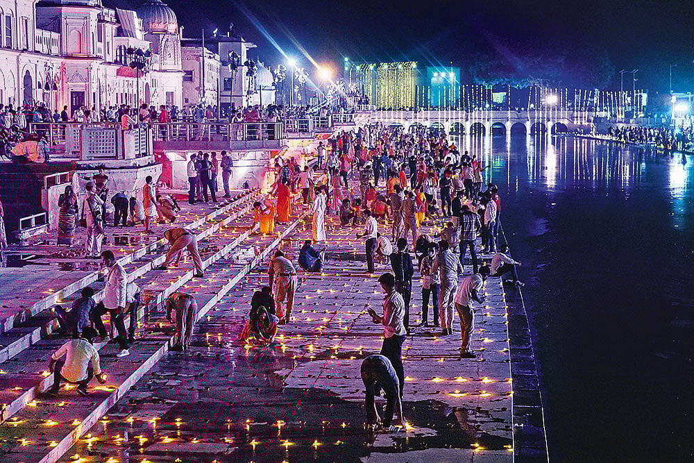 Photo: PTI : Illuminated Devotees light lamps at Ramghat in Ayodhya 