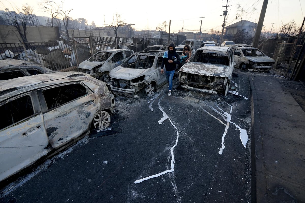 AP : Locals walk among burnt cars in Chile.