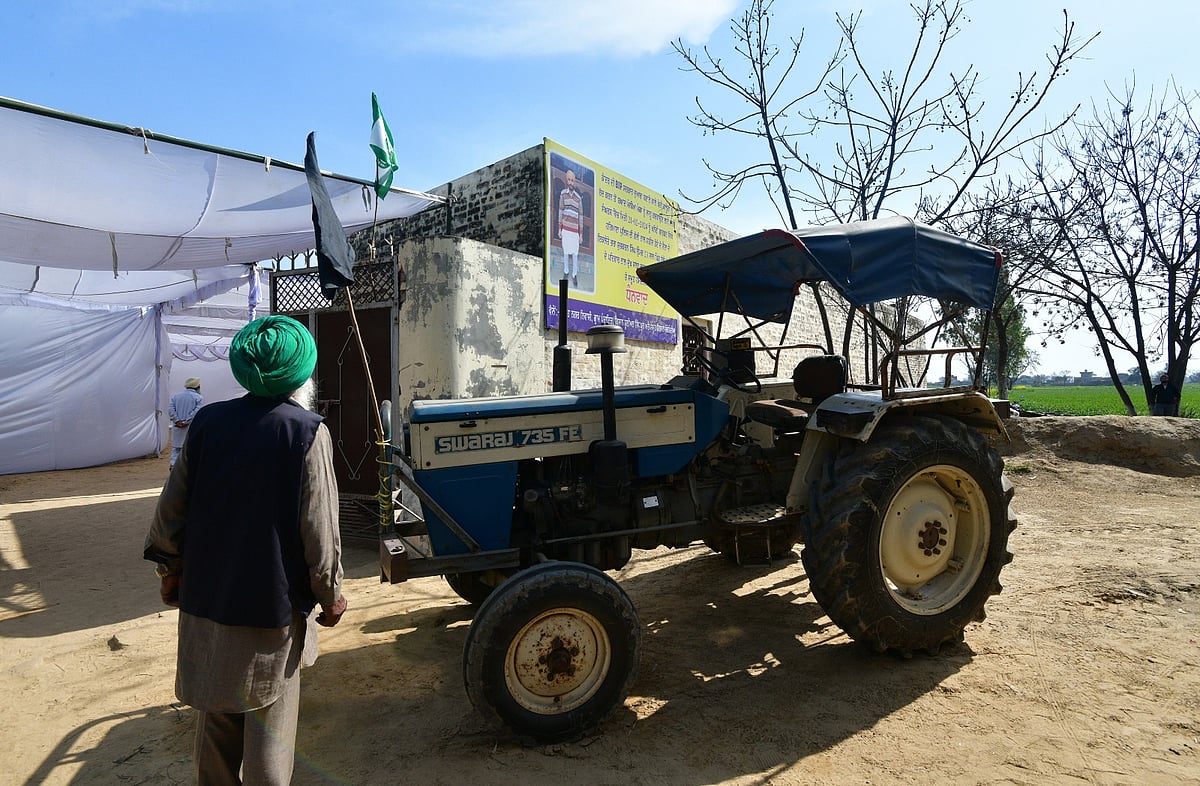 Tribhuvan Tiwari/Outlook India  : Shubhkaran's tractor parked outside his house, against a poster with his photograph in Baloh village. 