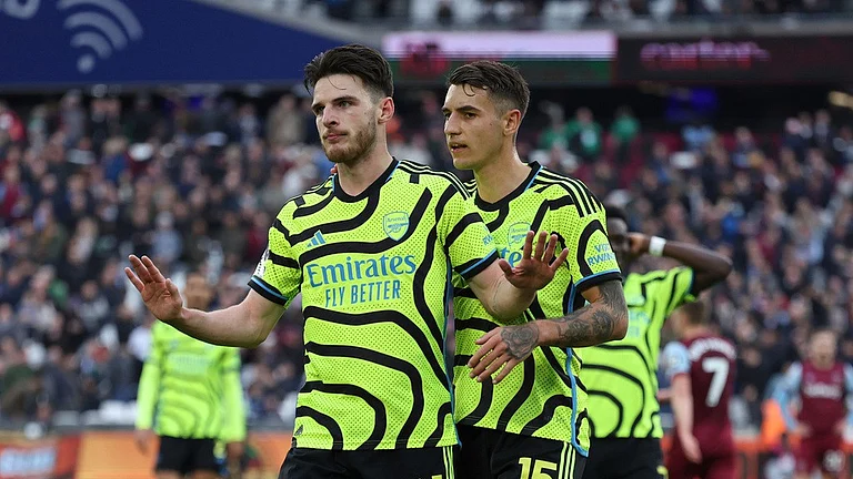 Arsenal's Declan Rice puts his hands up but does not celebrate after scoring Arsenal's 6th goal against his former club West Ham United during their English Premier League match at the London Stadium in London on February 11, 2024. - AP