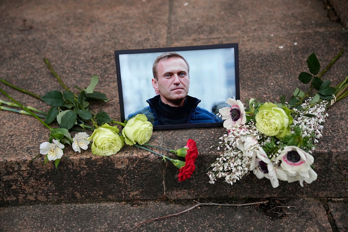 A portrait of Russian opposition leader Alexei Navalny and flowers are pictured as people demonstrate near to Russian embassy to France after Russian authorities reported his death in prison. - AP Photo/Christophe Ena