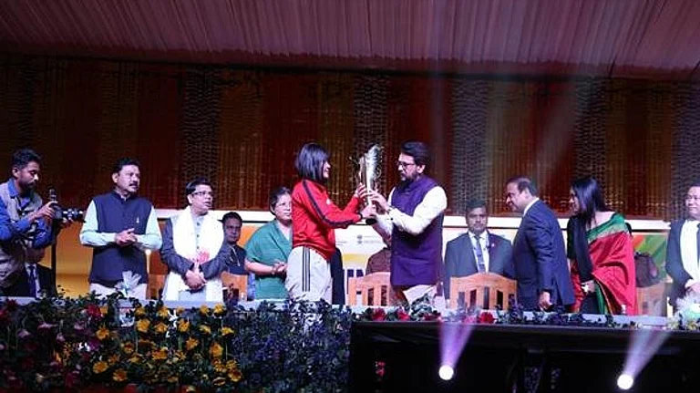 International boxer Jamuna Boro handing over the Khelo India University Games 2023 torch to Union Minister for Sports and Youth Affairs Shri Anurag Singh Thakur at the Sarusajai Sports Complex in Guwahati on Monday. - Khelo India