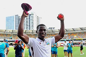 Jono Searle/AAP Image via AP : West Indies' Shamar Joseph raises the ball after taking 7 wickets in his team's victory against Australia on the 4th day of the 2nd test match in Brisbane