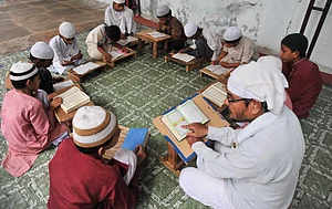 Getty Images : Indian Muslim students receive instruction from a teacher as they read religious texts at the Madrasa-E-Faizul Quran Education Centre (representative image)