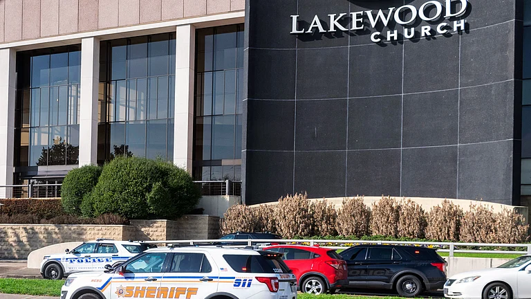 Emergency vehicles line the feeder road outside Lakewood Church during a reported active shooter event. - AP