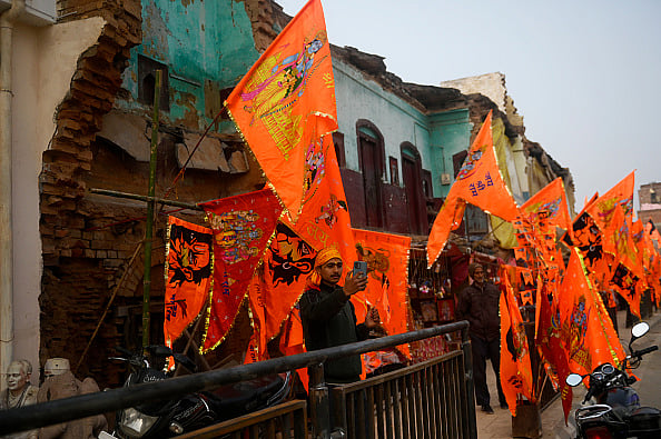 A man is taking a selfie in front of saffron flags ahead of the opening of the Hindu Ram Temple in Ayodhya (representative image) - Getty Images