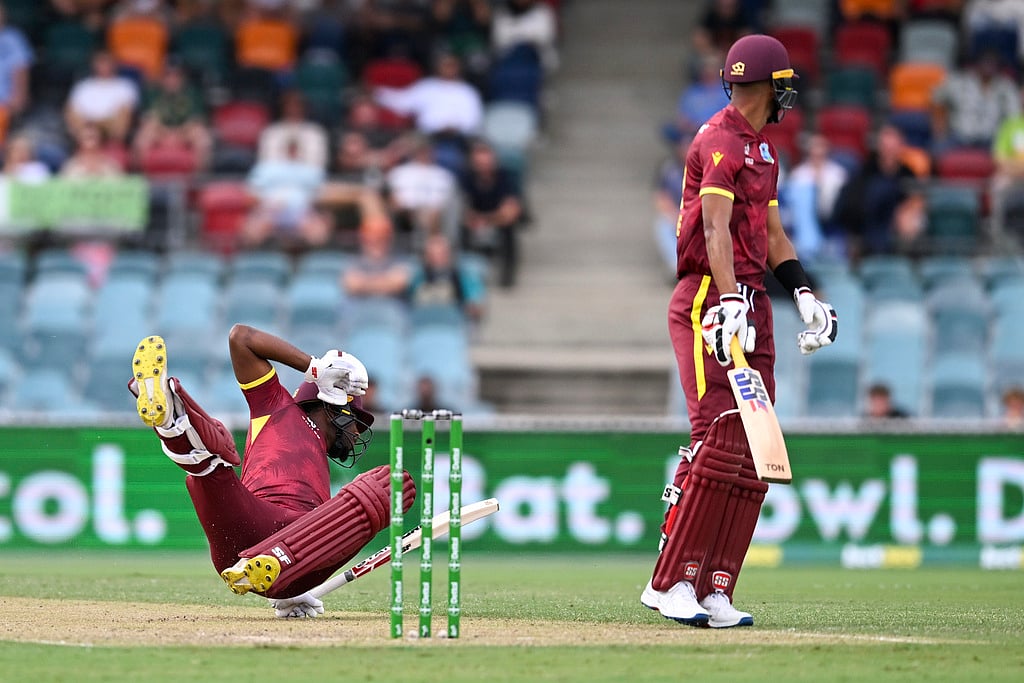 Photo: Lukas Coch/AAP via AP : Matthew Forde (left) falls as he is run out during the third one day international between Australia and the West Indies at the Manuka Oval in Canberra.