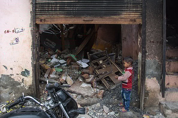 Getty Images : A kid playing outside the gutted shop in Shiv Vihar which become the haunted colony for muslims, the worst affected locality of Delhi riots.