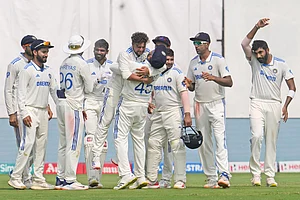 Photo: AP/Manish Swarup : Captain Rohit Sharma lifts Kuldeep Yadav after he took Zak Crawley's wicket on the fourth day of the second cricket Test match between India and England in Visakhapatnam.