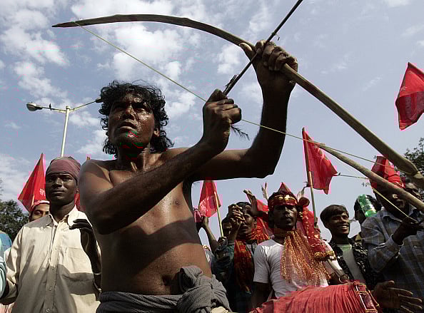 Getty Images : An Indian tribal villager aims with his bow and arrow as he takes part in a rally in Kolkata on February 8, 2008.