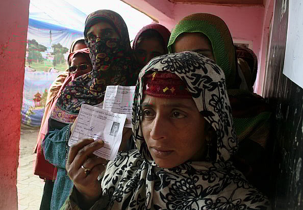 Kashmiri women wait in queue to cast their votes outside a polling station during the second phase of assembly elections on December 02, 2014, in Kulgam. - (Photo by Yawar Nazir/Getty Images)
