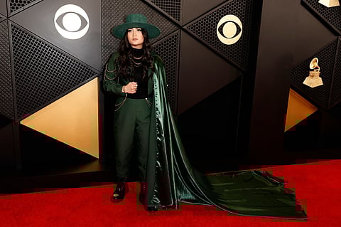Alex Ritchie made her suit look even cooler by adding a long, flowy green cape, a big hat that matches, and some shiny gold chains.