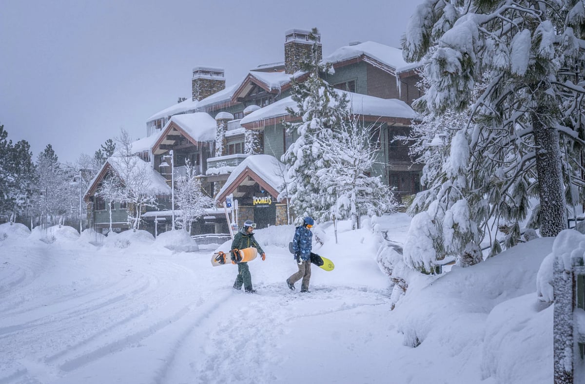 Snowboarders walking in the snow - AP