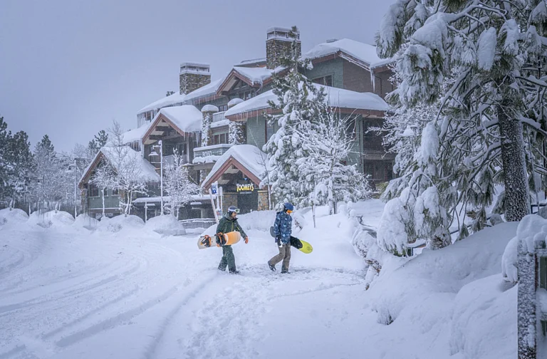 Snowboarders walking in the snow - AP