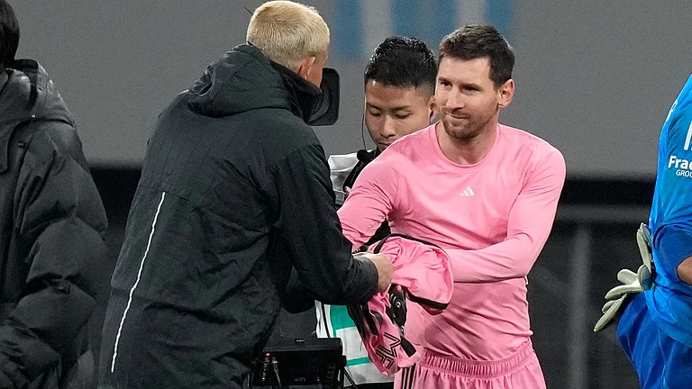 Inter Miami's Lionel Messi, right gives his jersey to a Vissel Kobe's official after their friendly soccer match at the National Stadium, Wednesday, Feb. 7, 2024, in Tokyo, Japan. - (AP Photo/Eugene Hoshiko)