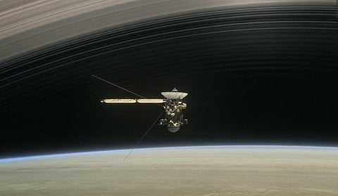 An illustration showing Cassini passing through the rings of Saturn.