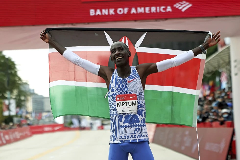 Photo - (Eileen T. Meslar/Chicago Tribune via AP) : FILE - Kelvin Kiptum of Kenya celebrates his Chicago Marathon world record victory in Chicago’s Grant Park on Sunday, Oct. 8, 2023.