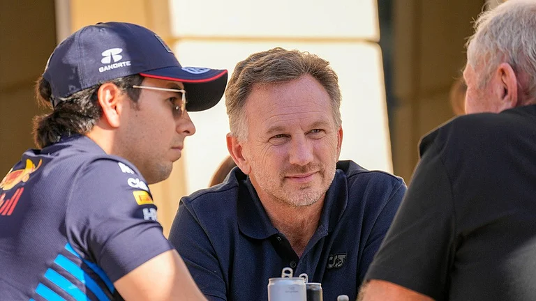 Red Bull team principal Christian Horner, centre, chats with driver Sergio Perez, left, and Helmut Marko, team director, right, at the pits during the Formula One pre-season test at the Bahrain International Circuit in Sakhir, Bahrain on February 21, 2024. - AP