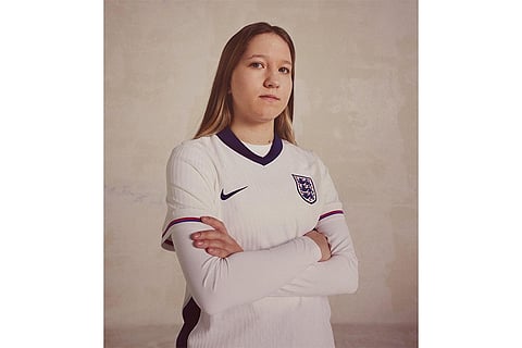 An England fan posing with the team jersey.