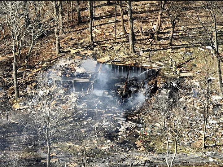 AP : Debris of a massive explosion, destroys a house, kills 2