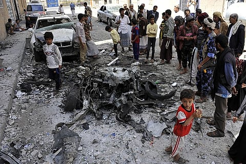 Yemenis gather around the site of a bomb attack which targeted a military hospital in the Ferai street of Sana'a, Yemen on June 30, 2015