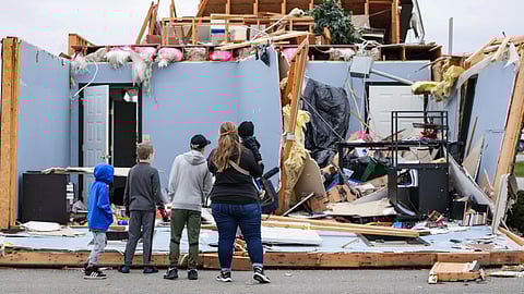 Courtney Holloway looks at what is left of the Freedom Life Church with her children after a severe storm demolished the church in Winchester.