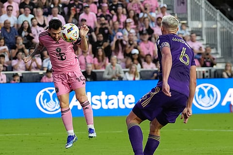 Inter Miami forward Lionel Messi (left) heads the ball past Orlando City defender Robin Jansson to score his side's fifth goal during the second half of an MLS match in Fort Lauderdale, Florida.