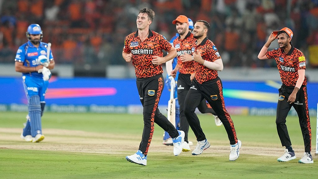 AP : SRH players led by their skipper Pat Cummins (c) celebrate a MI wicket.