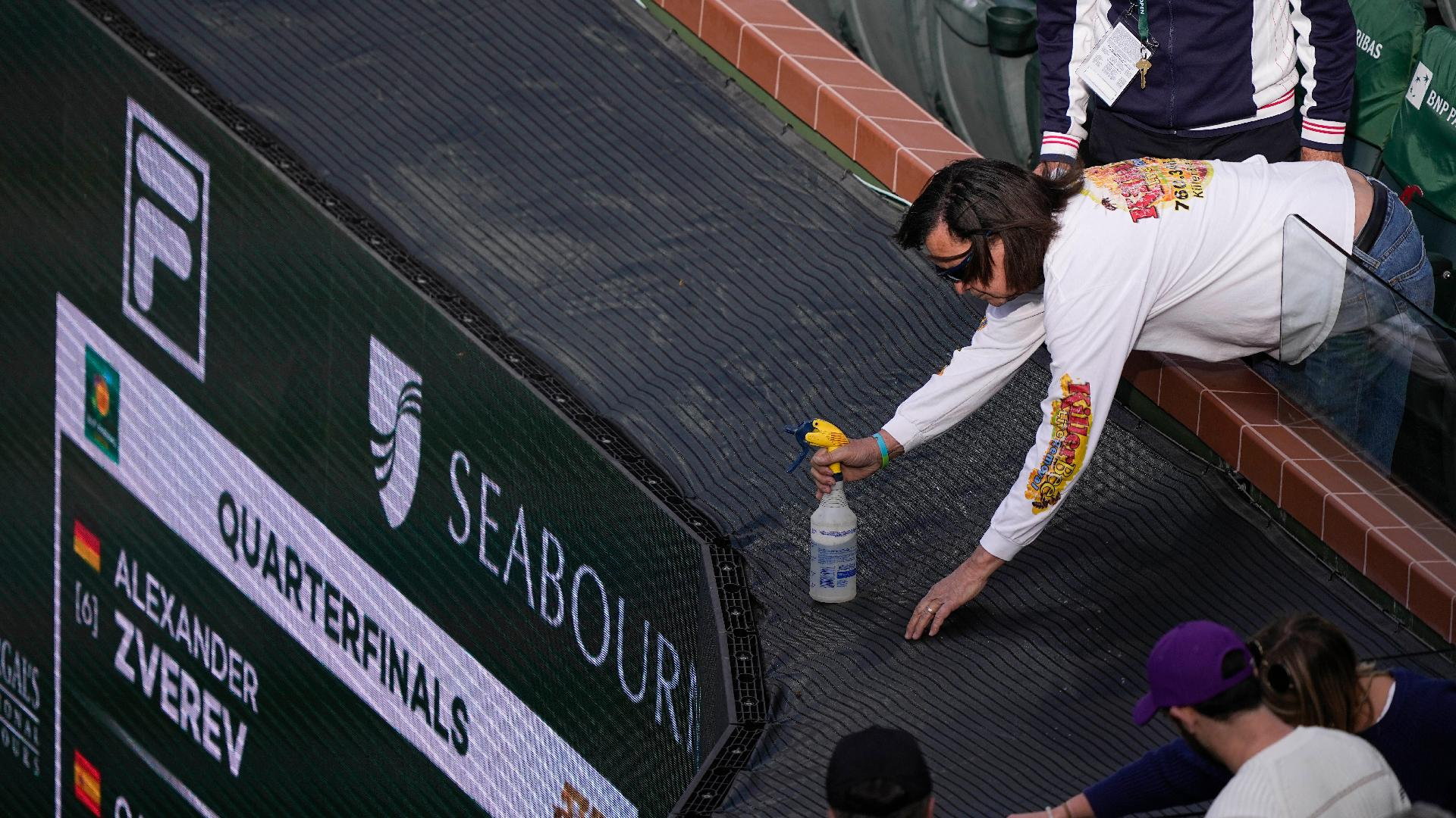A beekeeper sprays a bee during an interruption in play at Indian Wells. - Mark J Terrill/AP