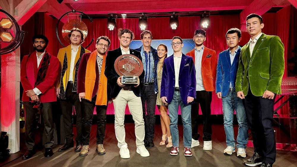 D Gukesh (leftmost) alongside Magnus Carlsen (holding trophy, centre) and other Grandmasters at the Freestyle Chess G.O.A.T Challenge 2024 event in Germany’s Weissenhaus.   - Freestyle Chess G.O.A.T Challenge