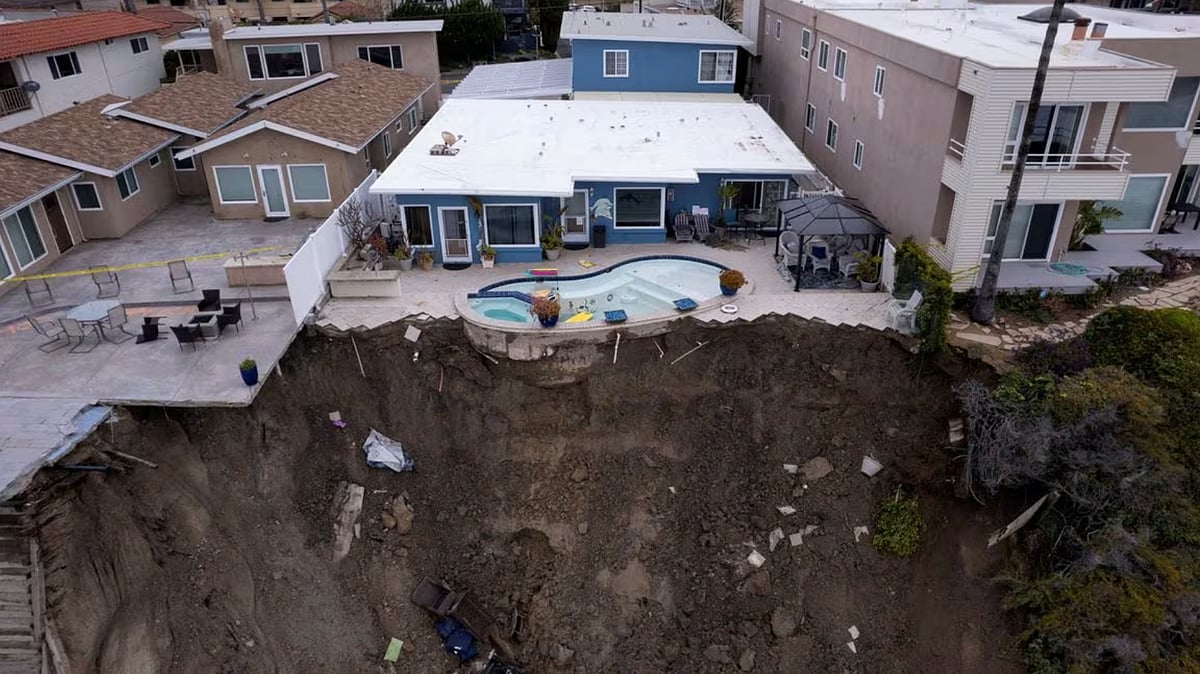 A backyard pool is left hanging on a cliffside after torrential rain brought havoc. - Reuters