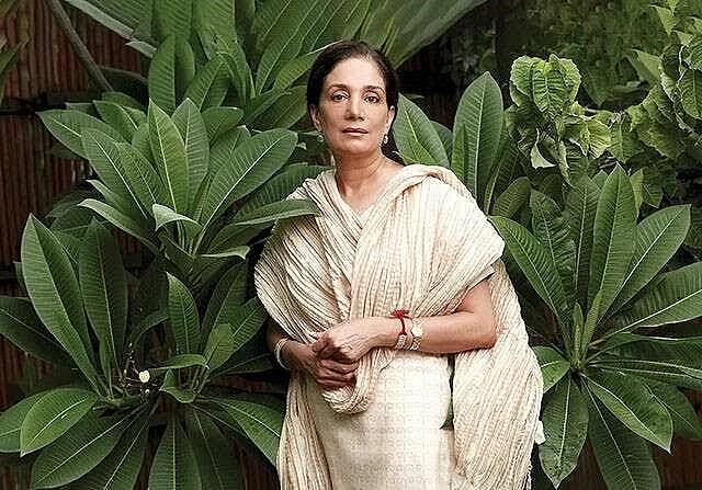Mira Kulkarni, Founder- Forest Essentials, in white dress next to plants
