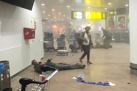 An injured man lies amongst debris following a suicide bombing at Brussels Zaventem airport on March 22, 2016 in Brussels, Belgium