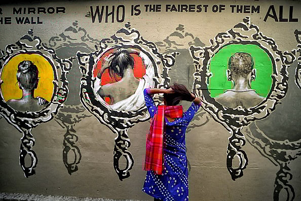 Getty Images : A young lady poses in front of a beautiful wall graffiti during an open air Art Fest (representative image)