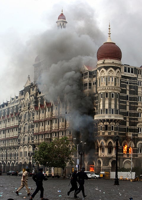 Firefighters attend to a fire as it burns at Taj Mahal Palace & Tower Hotel following an armed siege on November 29, 2008 in Mumbai
