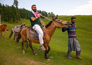 (Photo by Eric Lafforgue via Getty Images) : Indian tourist riding a horse, Jammu and Kashmir, Yusmarg, India on June 13, 2023 in Yusmarg, India