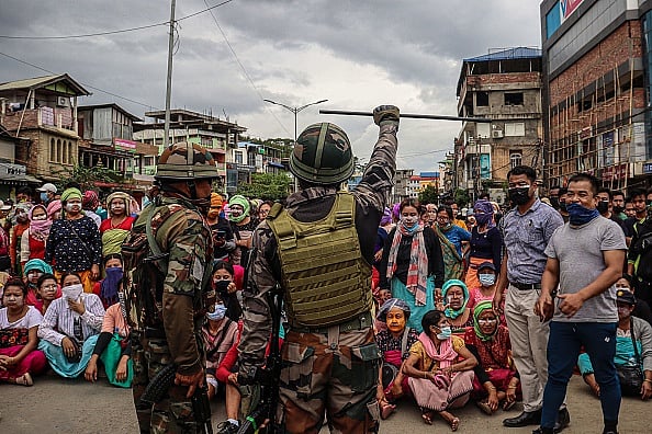 Army personnel stand guard as demonstrators protest against mass burial of Kuki-Zomi people killed in Manipur's ethnic violence, in Imphal on August 3, 2023. | - Getty Images