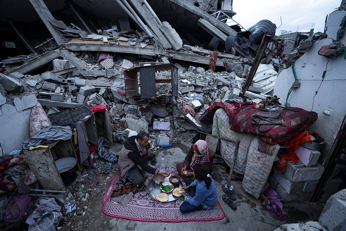 AP : Members of the Al-Rabaya family break their fast during the Muslim holy month of Ramadan outside their destroyed home by the Israeli airstrikes in Rafah, Gaza Strip, Monday, March 18, 2024. 