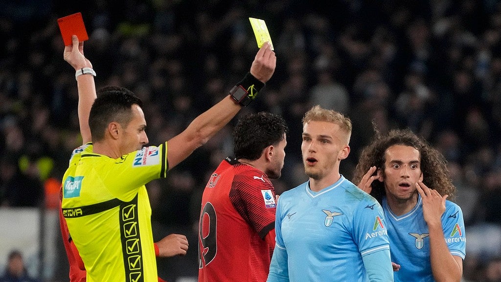 AP/Gregorio Borgia : Referee Marco di Bello shows the red card to Lazio's Matteo Guendouzi, background right, and the yellow card to AC Milan's Christian Pulisic during their Serie A 2023-24 football match at Rome's Olympic stadium on March 2.