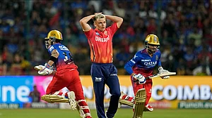 AP Photo/Aijaz Rahi : Punjab Kings' Sam Curran reacts after Royal Challengers Bengaluru's Virat Kohli, left, played a shot on his delivery during the Indian Premier League match between Royal Challengers Bengaluru and Punjab Kings in Bengaluru.