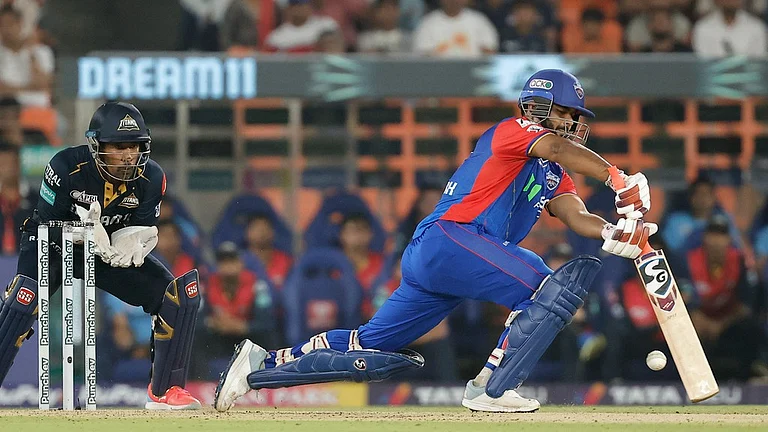 Delhi Capitals captain Rishabh Pant (right) bats as Gujarat Titans wicketkeeper Wriddhiman Saha looks on, during match 32 of Indian Premier League 2024 in Ahmedabad on Wednesday (April 17). - AP/Pravin Indrekar