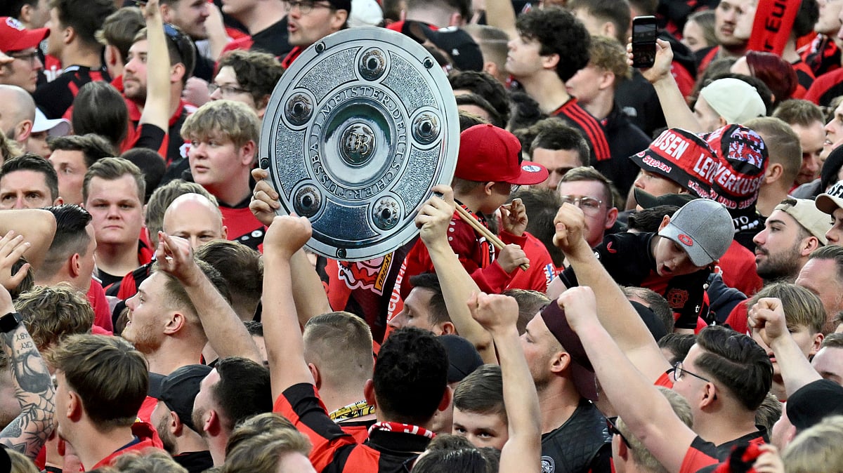 (Federico Gambarini/dpa via AP)
 : Leverkusen's fans raise a mock champions trophy as they celebrate winning the German championship on the pitch after the Bundesliga soccer match between Bayer Leverkusen and Werder Bremen at the BayArena in Leverkusen, Germany, Sunday, April 14, 2024. 