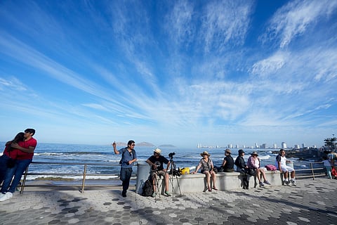 People wait to watch a total solar eclipse in Mazatlan, Mexico, Monday, April 8, 2024.