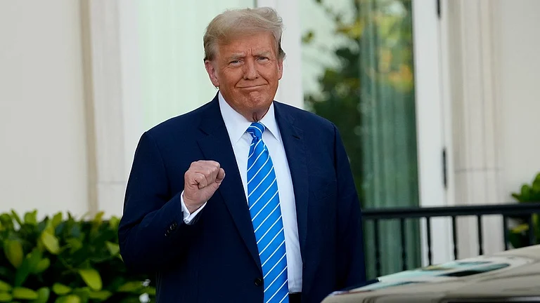 Donald Trump pumps his fist as he arrives for a GOP fundraiser, Saturday, April 6, 2024, in Palm Beach, Fla. - AP