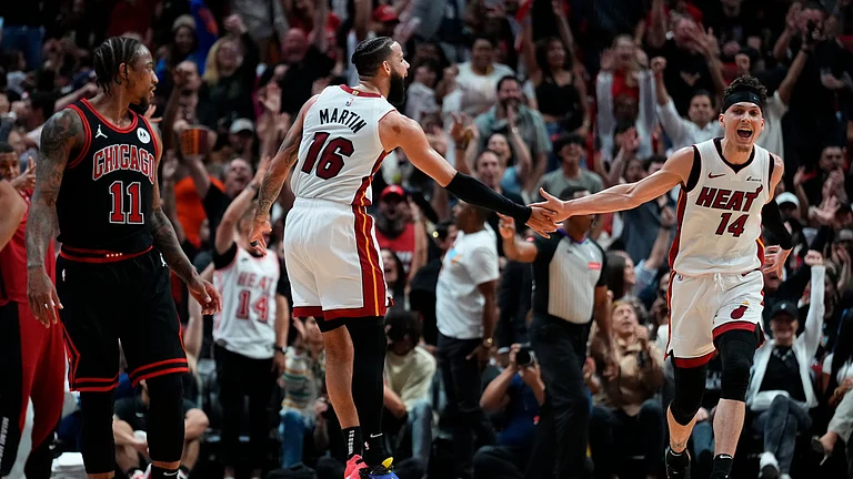 Caleb Martin #16 celebrates scoring a three-pointer with Tyler Herro #14 of the Miami Heat against the Chicago Bulls in the third quarter during the Play-In Tournament at Kaseya Center on April 19, 2024 - null