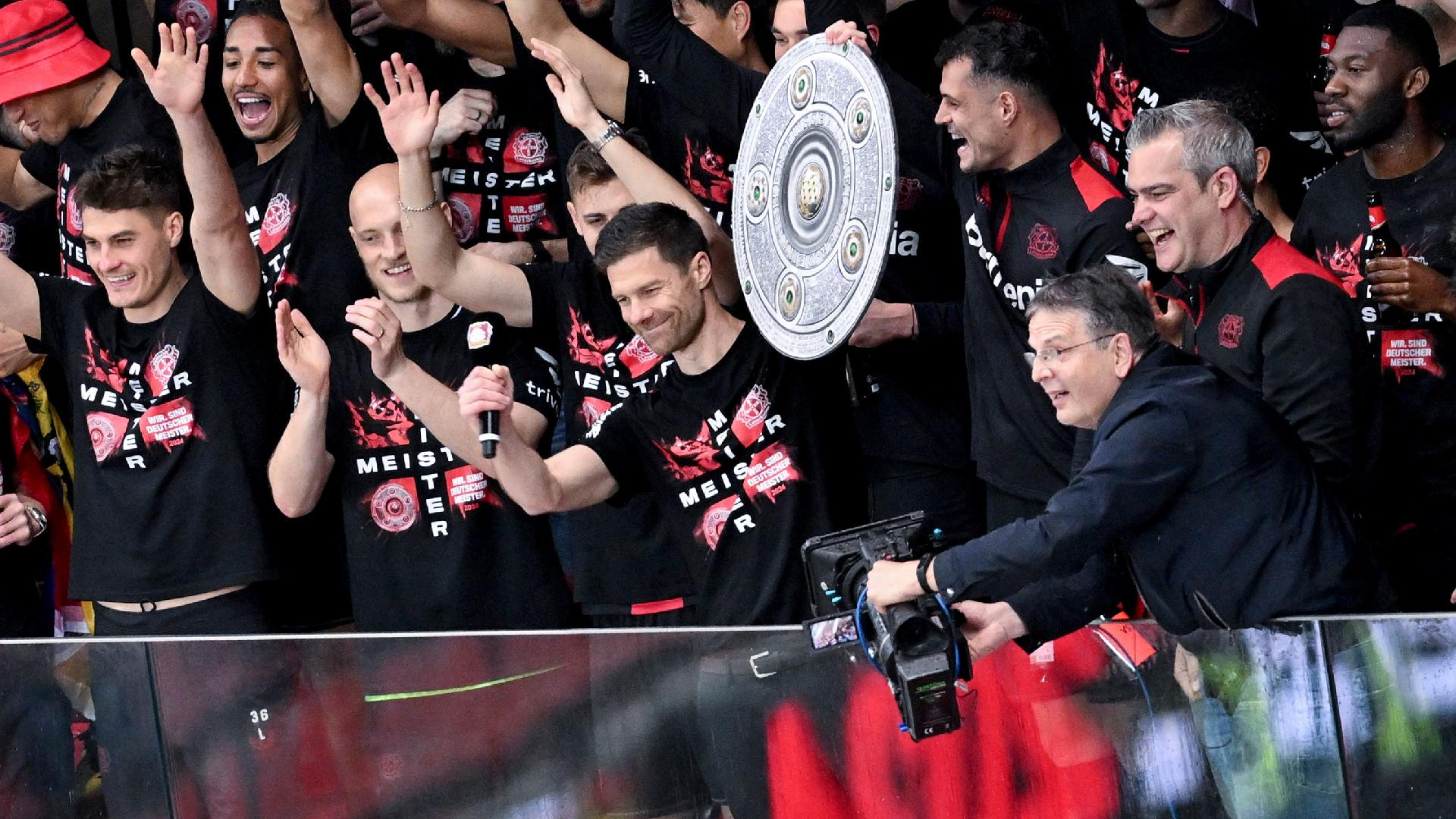 Coach Xabi Alonso, centre, and Bayer Leverkusen raise the Bundesliga trophy. - David Inderlied/dpa via AP