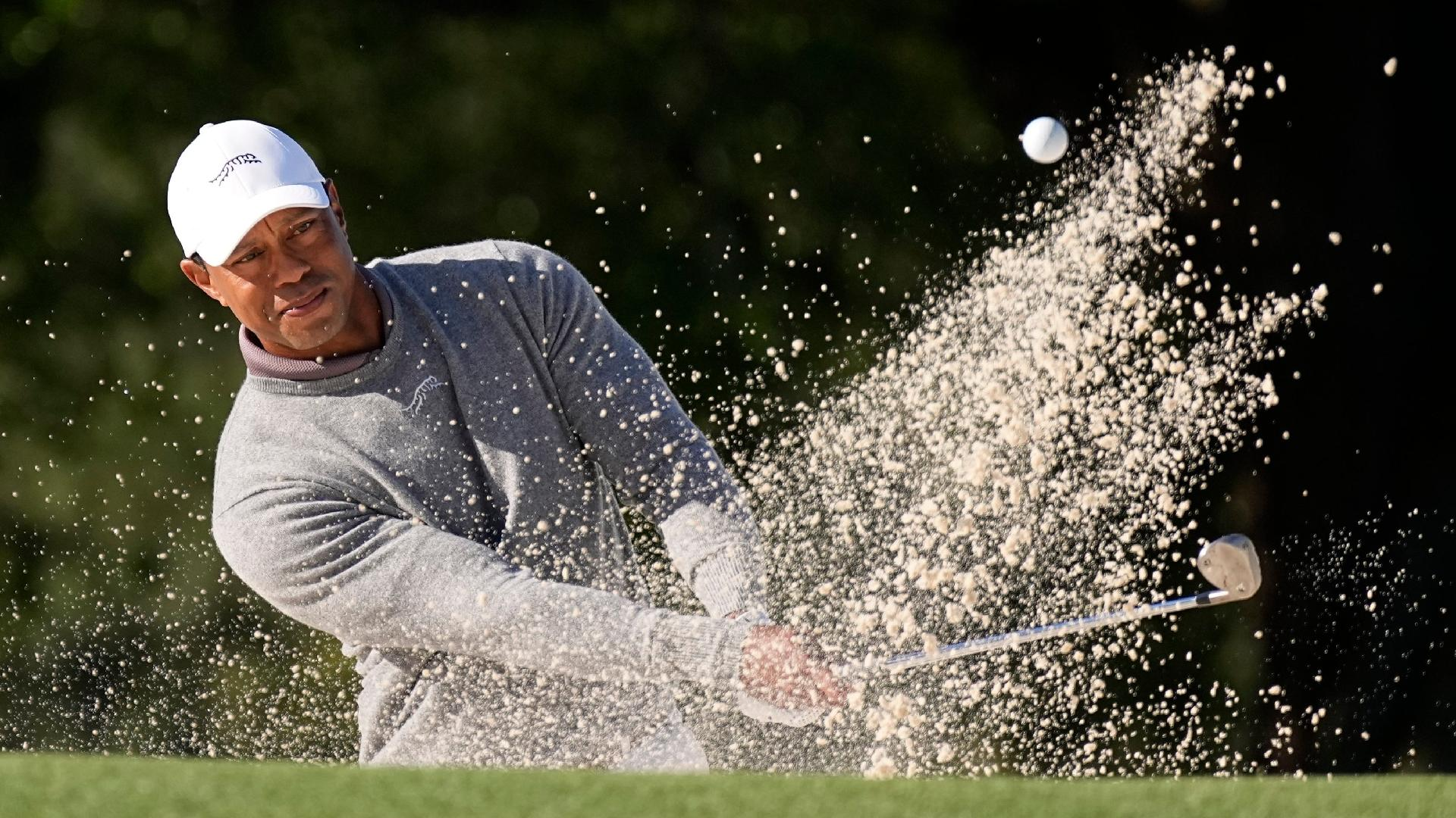 Tiger Woods hits from the bunker on the 18th hole during his first round of 73 in the 88th Masters. - George Walker IV/AP