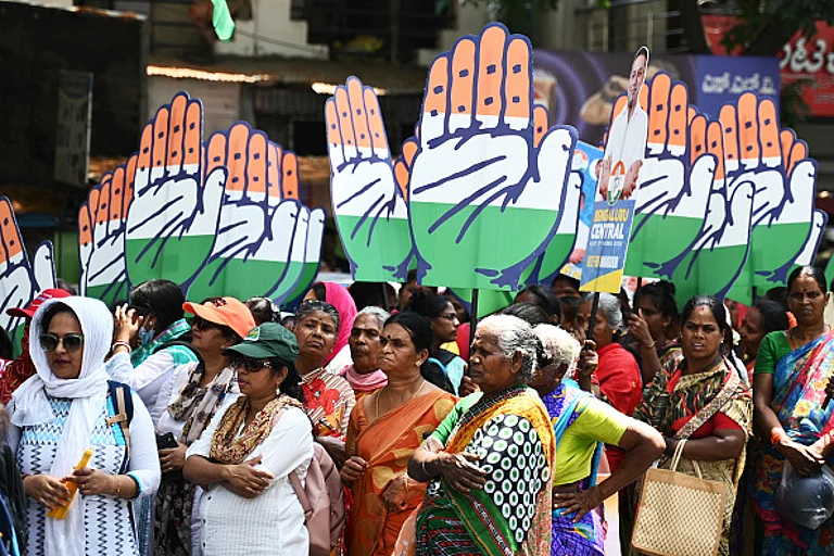 Congress party supporters hold the party's symbol during a roadshow for Mansoor Ali Khan, election candidate for Bengaluru central - Getty Images