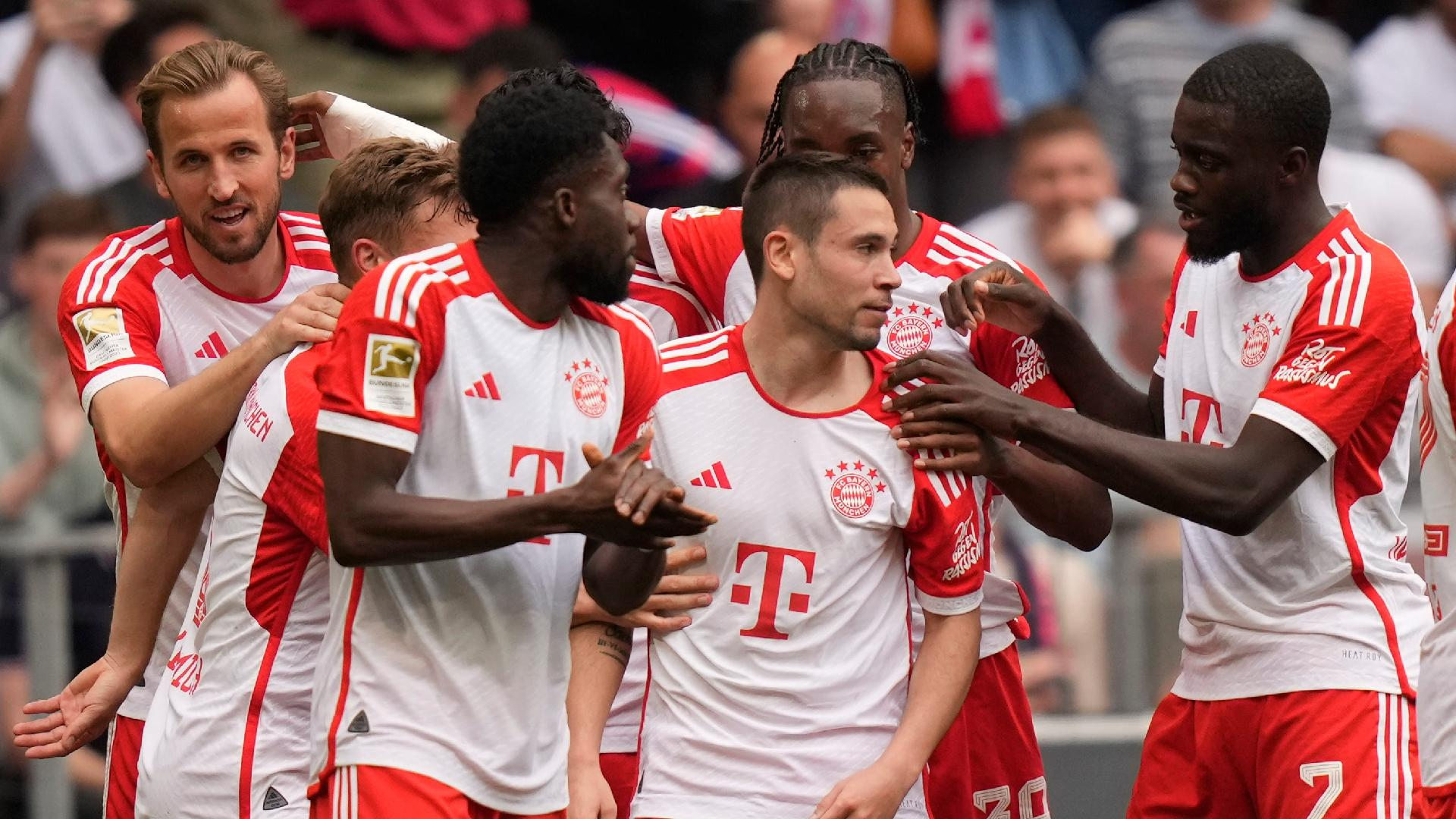 Matthias Schrader/AP : Raphael Guerreiro (centre) is mobbed by his Bayern Munich team-mates after scoring against Koln.