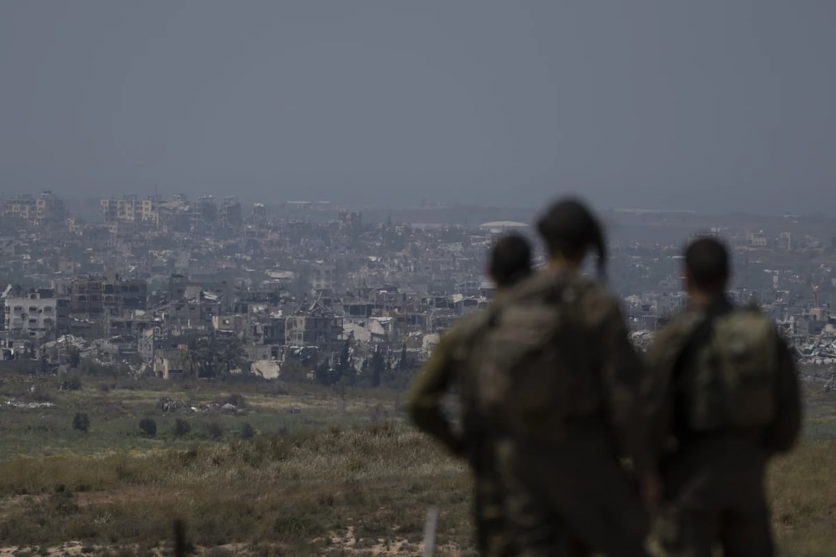 Israeli soldiers look at destroyed buildings in Gaza strip | - AP